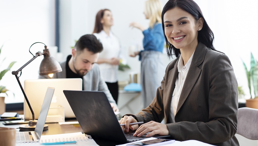 Mulher em um escritório compartilhado trabalhando com um laptop